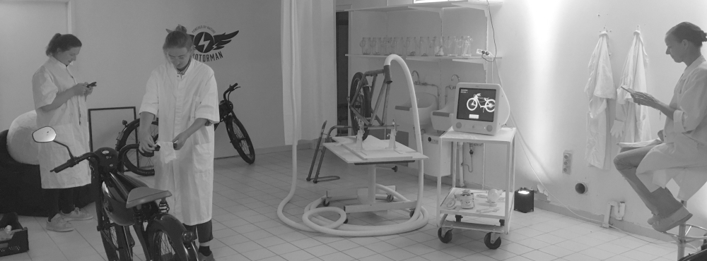 drie personen aan het werk in een labo met electrische motorfietsen